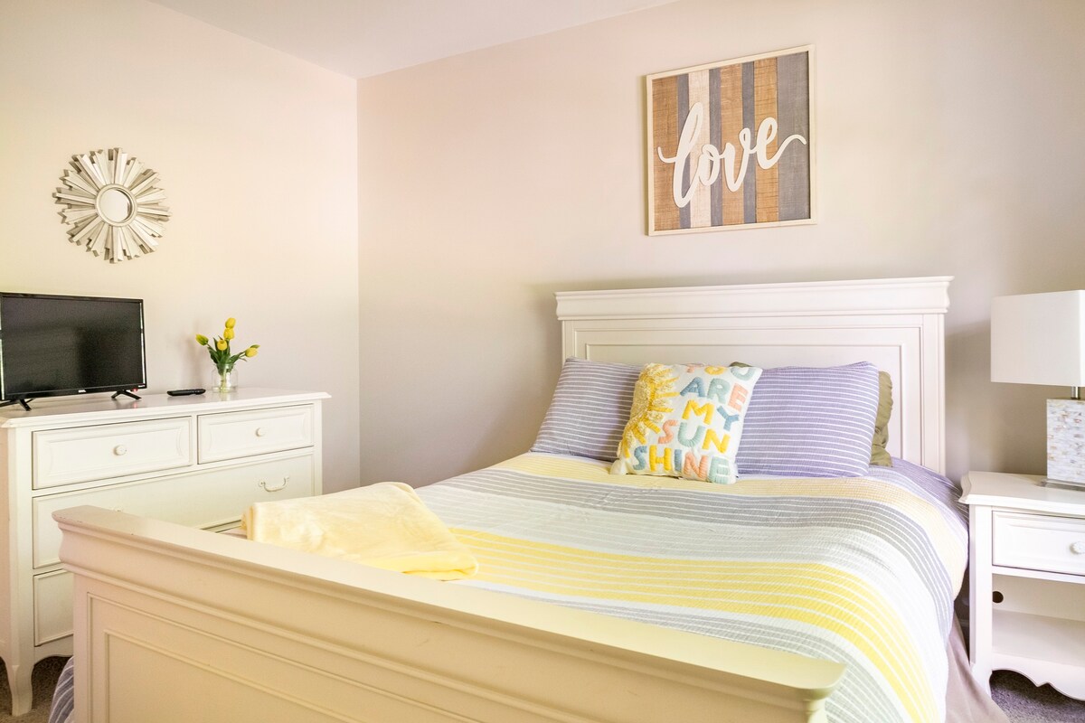 Master bedroom with white furniture and cheerful yellow accents