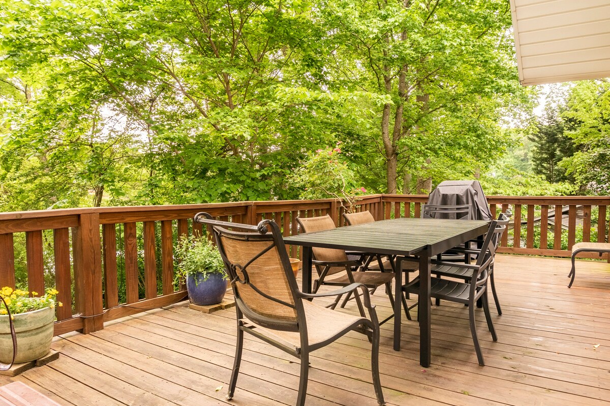 Deck dining area with outdoor furniture and forest views