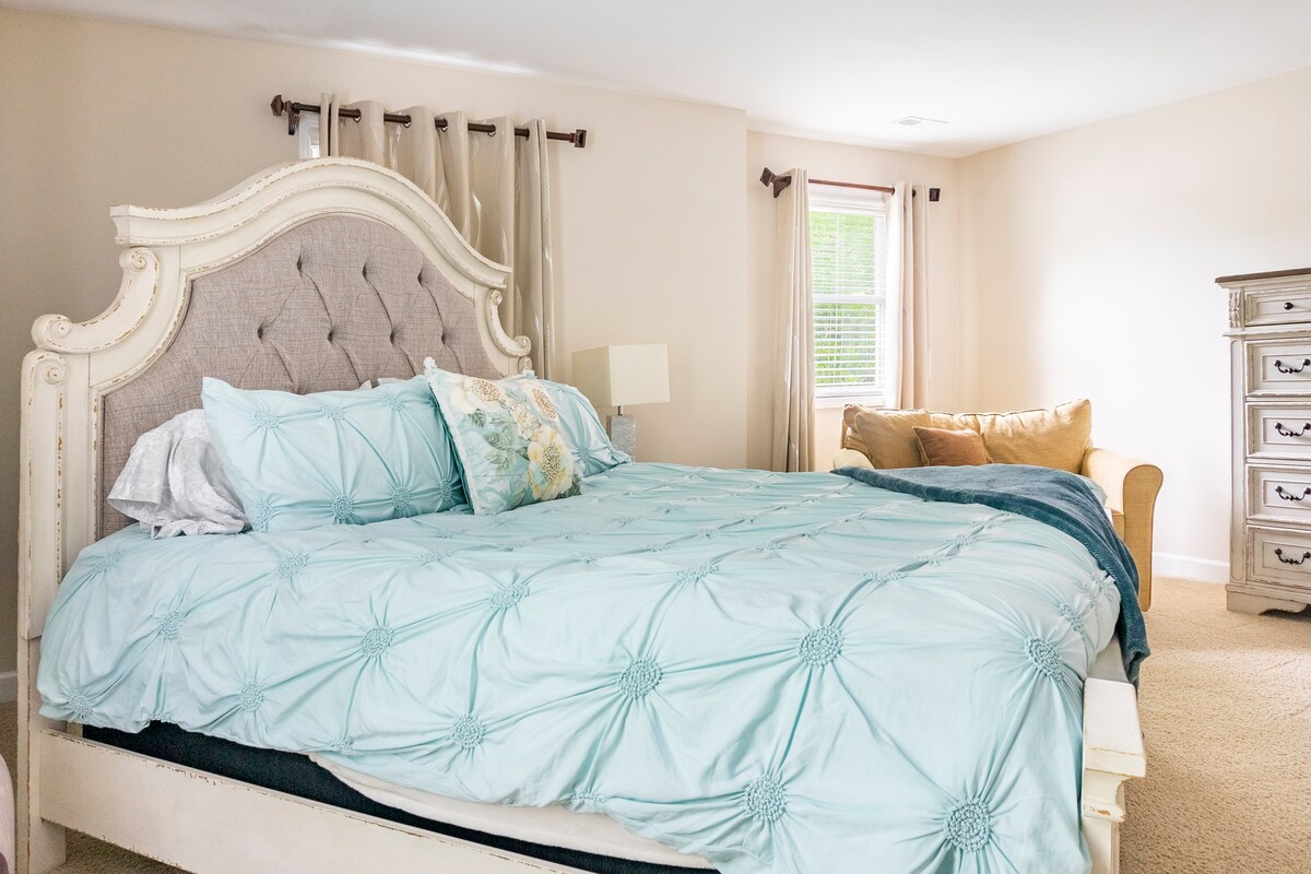 Elegant master bedroom with tufted headboard and aqua bedding
