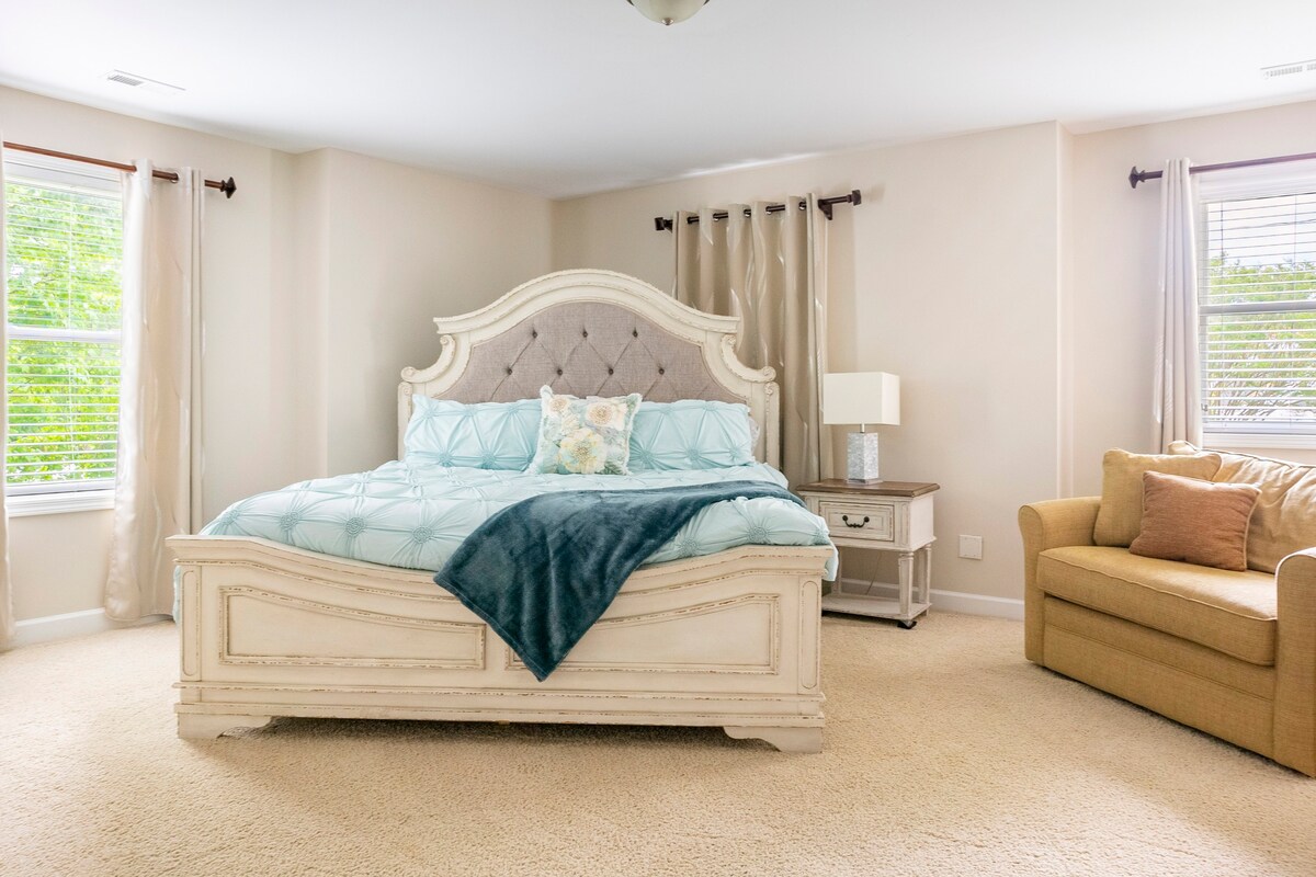 Large master bedroom with seating area and elegant furnishings