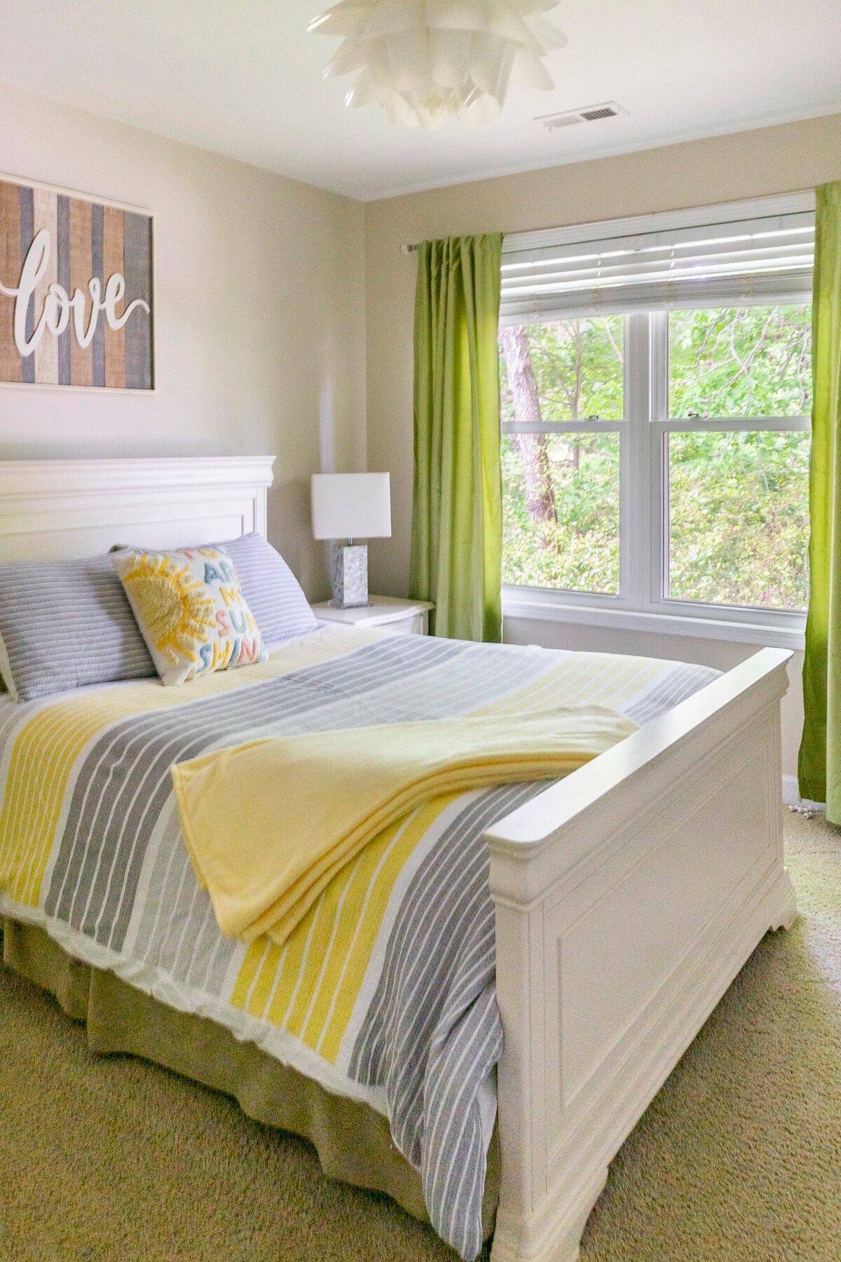 Bedroom with white furniture, yellow accents, and green curtains